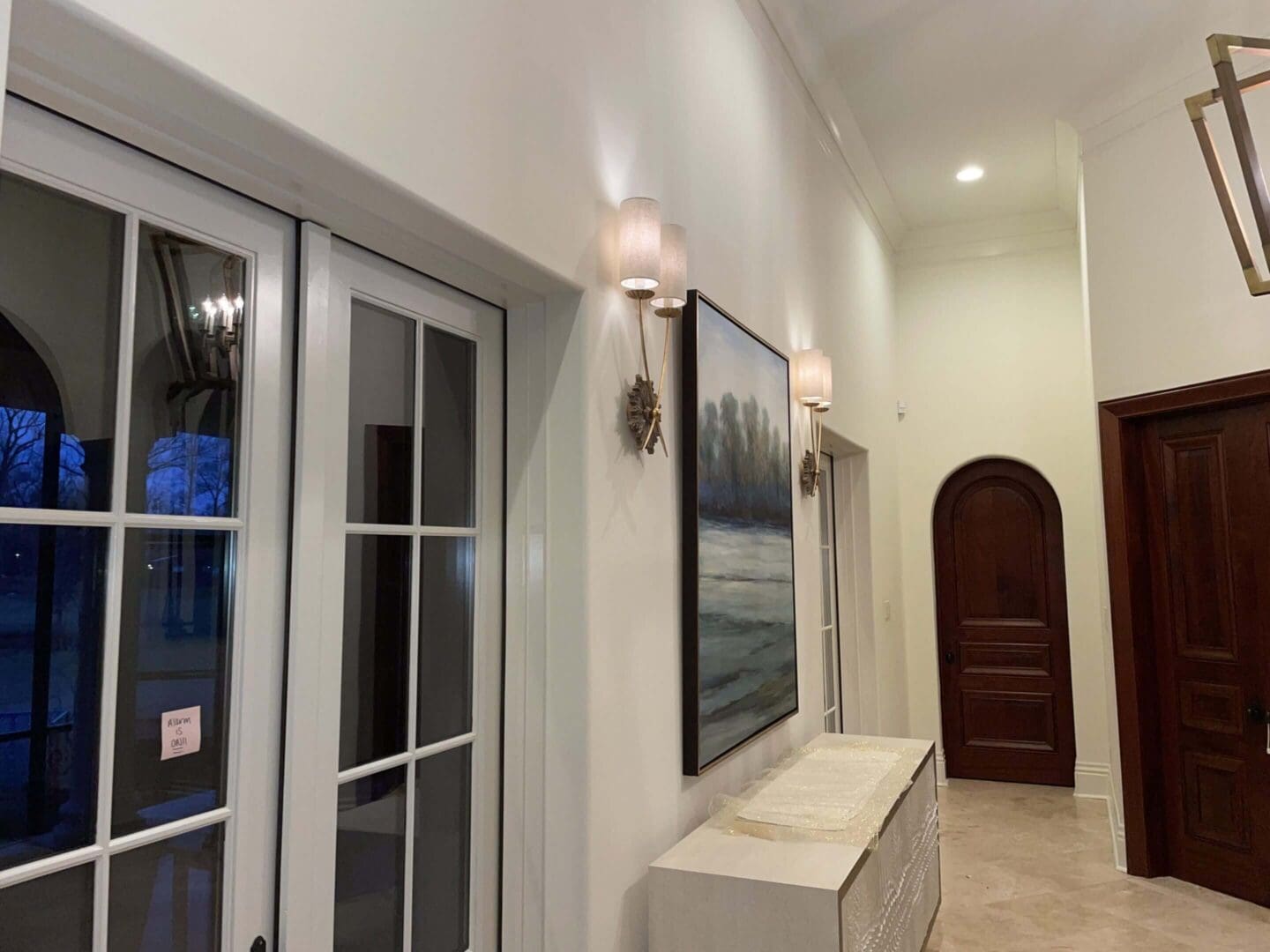 Bright hallway with artwork and sconces.