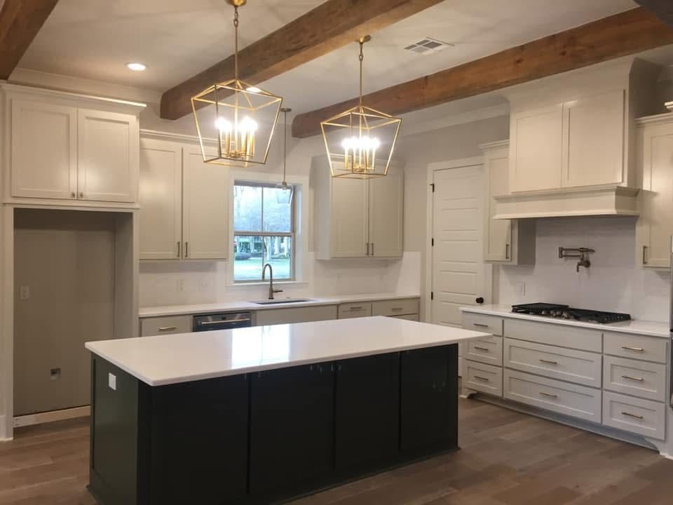 Modern kitchen with island and pendant lights.