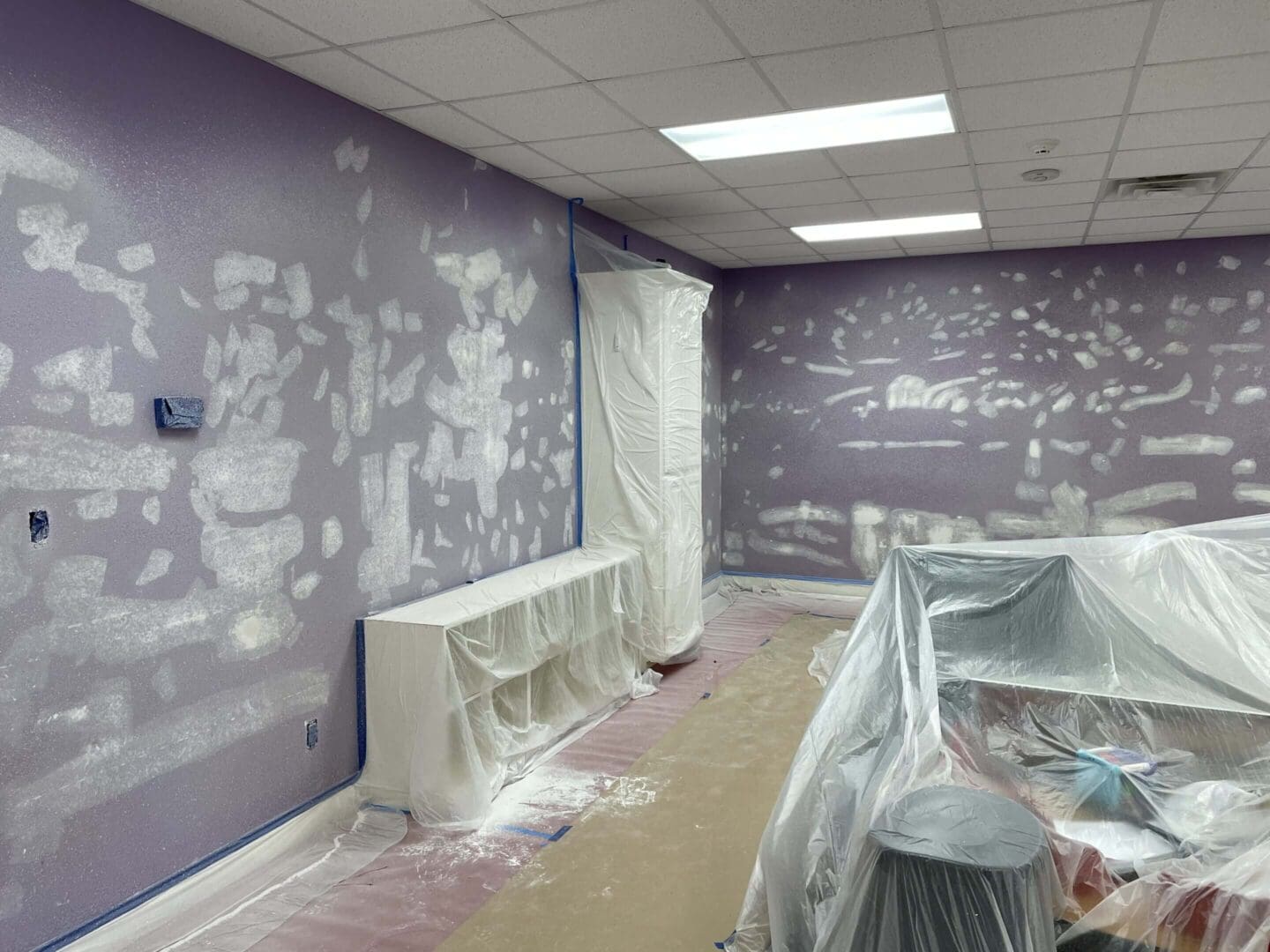 Room under renovation with purple walls.